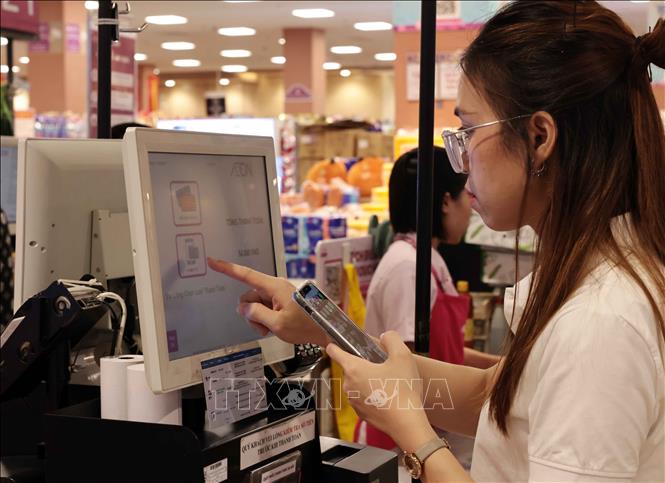 A customer makes a cashless transaction at AEON supermarket in Hanoi. VNA Photo: Trần Việt