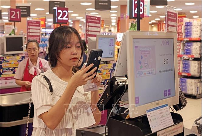 A customer makes a cashless transaction at AEON supermarket in Hanoi. VNA Photo: Trần Việt
