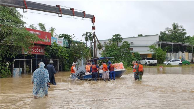 Đưa ca nô vào vùng rốn lũ hỗ trợ người dân Khánh Hòa bị cô lập trong mưa lũ. Ảnh: Nguyễn Thành - TTXVN