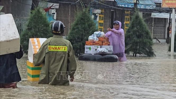 Nhu yếu phẩm, lương thực và nước sạch được tổ dân phố phường Bắc Nha Trang chuyển đến tận tay người dân tại các vùng bị nước lũ bao vây. Ảnh: Đặng Tuấn – TTXVN
