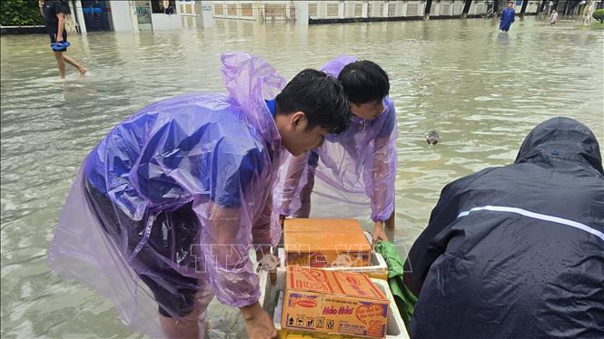 Nhu yếu phẩm, lương thực và nước sạch được đoàn thể các cấp chuyển đến tận tay người dân tại các vùng bị nước lũ bao vây. Ảnh: Đặng Tuấn – TTXVN