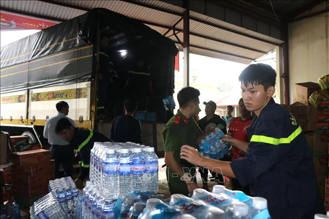 Cán bộ Công an tỉnh Đắk Lắk khẩn trương bốc nhu yếu phẩm để nhanh chóng gửi đến người dân vùng lũ. Ảnh: Nguyên Dung – TTXVN 