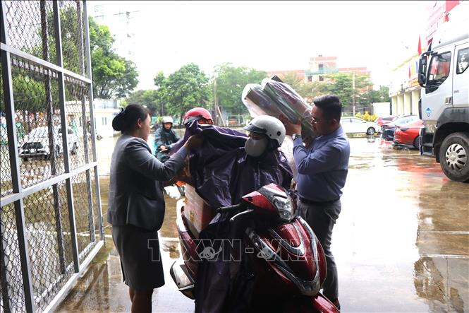 Nhiều người dân đội mưa mang nhu yếu phẩm đến quyên góp, hỗ trợ. Ảnh: Nguyên Dung – TTXVN 