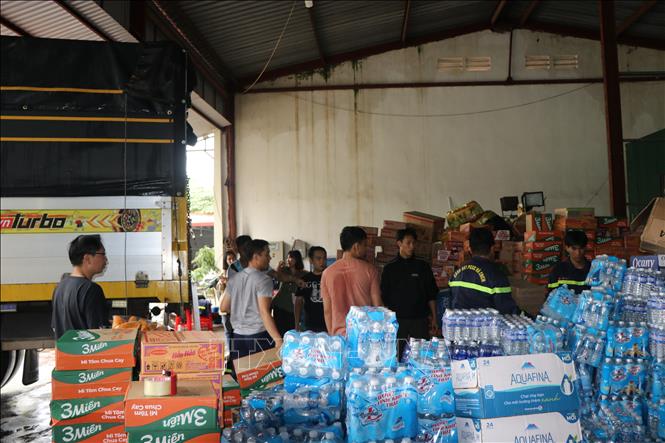 Cán bộ Công an tỉnh Đắk Lắk khẩn trương bốc nhu yếu phẩm để nhanh chóng gửi đến người dân vùng lũ. Ảnh: Nguyên Dung – TTXVN 