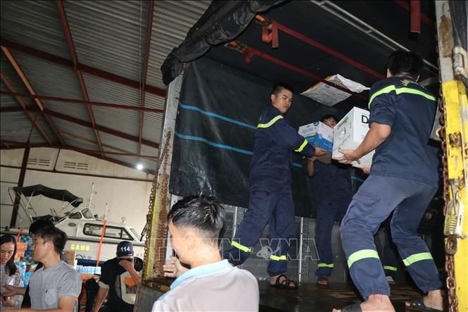 Cán bộ Công an tỉnh Đắk Lắk khẩn trương bốc nhu yếu phẩm để nhanh chóng gửi đến bà con vùng lũ. Ảnh: Nguyên Dung – TTXVN 