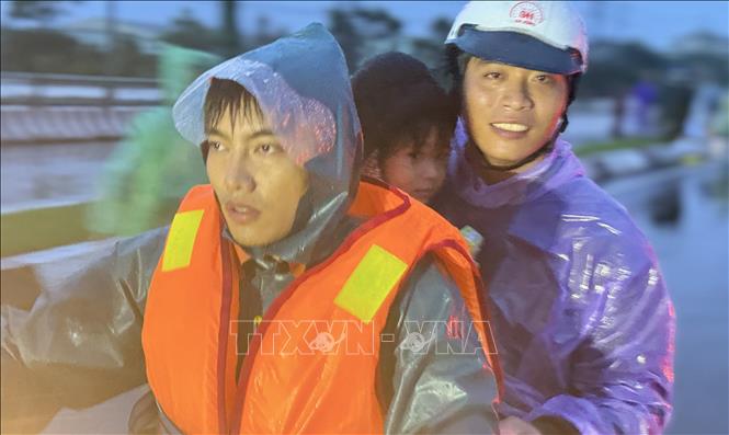 Lực lượng cứu hộ khẩn trương đưa một em nhỏ đến nơi an toàn. Ảnh: Tường Quân - TTXVN