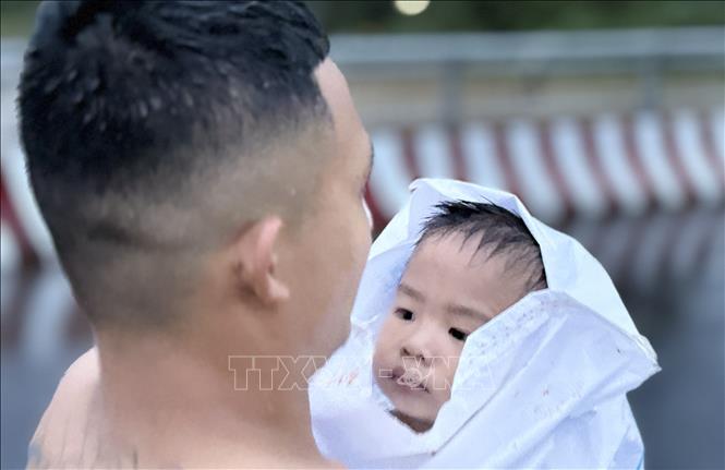 Lực lượng cứu hộ kịp thời sơ tán một em nhỏ vùng ngập lụt ở phường Tuy Hoà, Đắk Lắk chiều tối 20/11. Ảnh: Tường Quân - TTXVN
