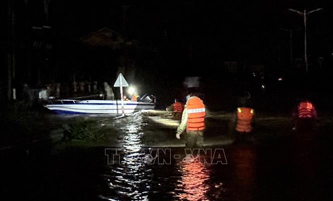 Lực lượng chức năng dùng ca nô di dời người dân vùng ngập lũ ở phường Tuy Hoà (Đắk Lắk) trong đêm. Ảnh: Tường Quân - TTXVN