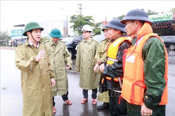 Ông Nghiêm Xuân Thành, Bí thư Tỉnh ủy Khánh Hòa (ngoài cùng bên trái) chỉ đạo công tác ứng cứu người dân khu vực ngập lụt. Ảnh: Xuân Triệu - TTXVN