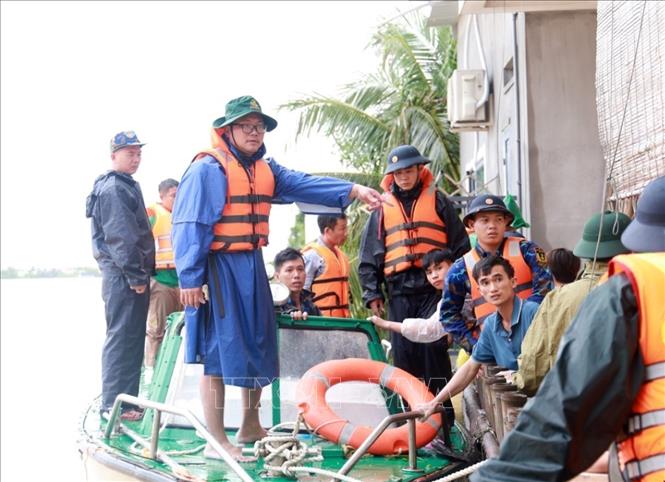 Người dân xã Suối Hiệp, tỉnh Khánh Hòa được lực lượng cứu hộ sử dụng phương tiện chuyên dụng đưa đến nơi an toàn. Ảnh: Xuân Triệu - TTXVN