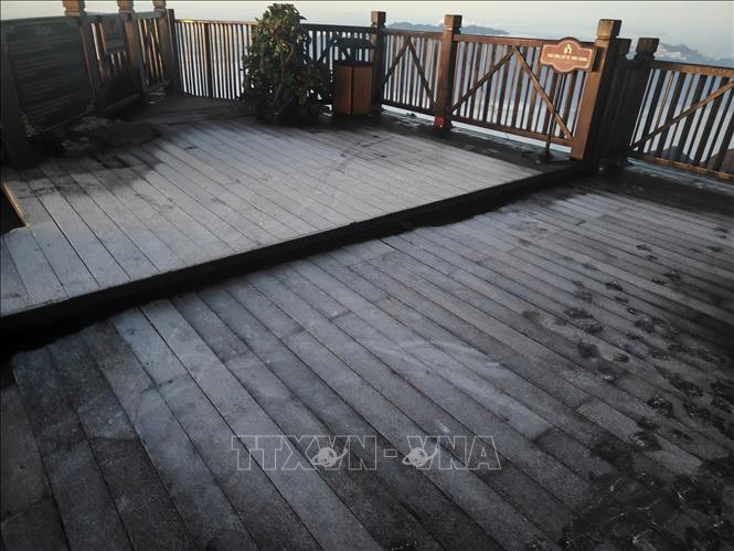 Sương muối phủ một lớp trắng mỏng trên sàn gỗ đỉnh Fansipan, nơi khách du lịch thường ngắm mây. Ảnh: TTXVN phát 