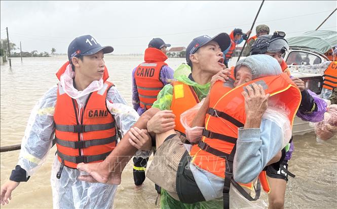 Lực lượng chức năng sơ tán một cụ già trong vùng ngập lũ ở xã Hòa Thịnh, Đắk Lắk đến nơi an toàn. Ảnh: Tường Quân - TTXVN
