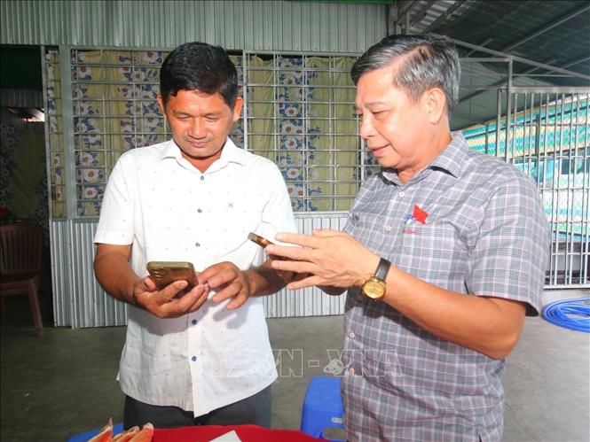 Ông Đồng Văn Thanh, Phó Bí thư Thường trực Thành ủy, Chủ tịch HĐND thành phố Cần Thơ trao đổi với lãnh đạo hợp tác xã Nông nghiệp Ruby Hậu Giang. Ảnh: Duy Khương - TTXVN