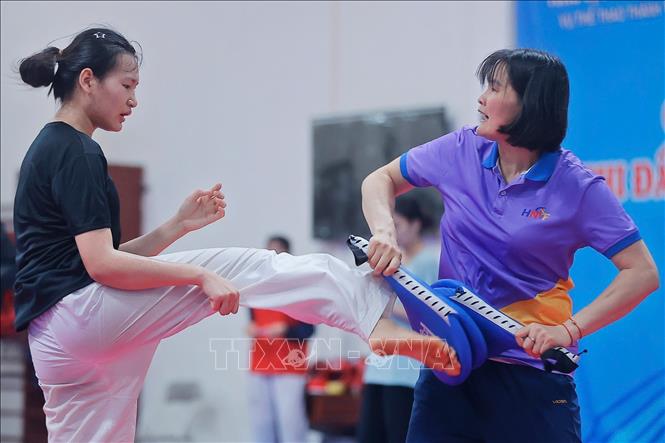 HLV Hà Thị Nguyên (áo tím) tập luyện thể lực và chiến thuật cho VĐV. Ảnh: Minh Quyết - TTXVN