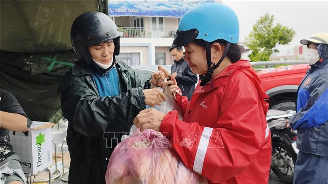 Hỗ trợ thức ăn, nước uống cho người dân Khánh Hòa bị ảnh hưởng mưa lũ. Ảnh: Nguyễn Thành – TTXVN