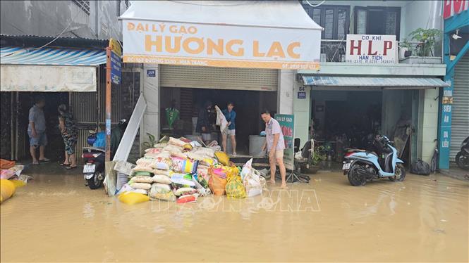 Một cửa hàng gạo bị thiệt hại nặng đang được dọn dẹp đất bùn sau khi nước rút. Ảnh: Đặng Tuấn - TTXVN 
