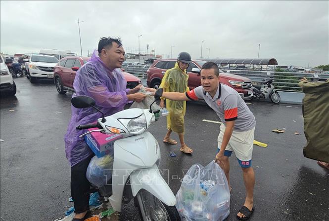 Ông Đinh Tấn Kỳ (phải), chủ tiệm cơm Nha Trang, mỗi ngày nấu 2000-3000 suất cơm để đưa đến điểm cứu trợ. Ảnh: Đặng Tuấn - TTXVN 