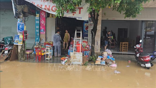 Người dân tranh thủ dọn nhà ngay khi nước rút. Ảnh: Đặng Tuấn - TTXVN 