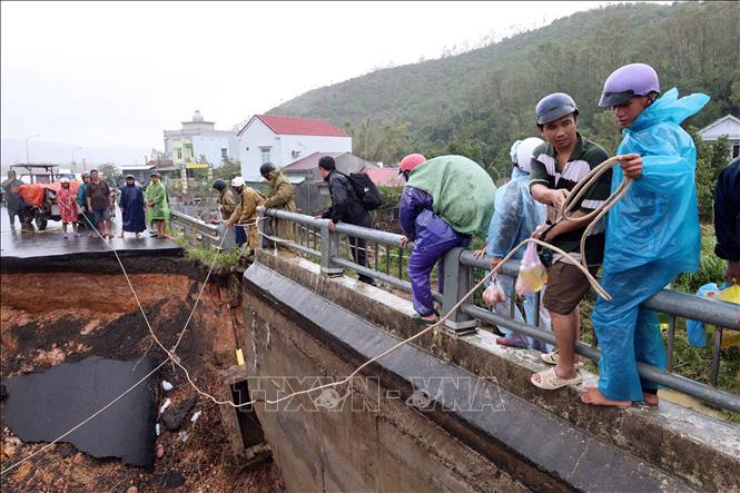 Người dân mạo hiểm vịn lan can qua cầu Lò Gốm. Ảnh: Đỗ Trưởng – TTXVN