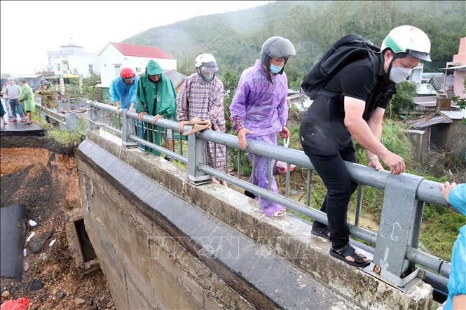 Người dân mạo hiểm vịn lan can qua cầu Lò Gốm. Ảnh: Đỗ Trưởng – TTXVN