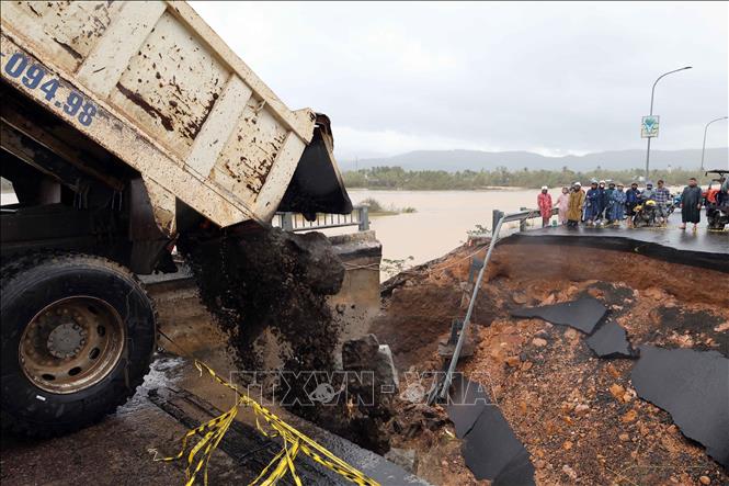 Đổ đất đá khắc phục sự cố sập mố cầu Lò Gốm. Ảnh: Đỗ Trưởng – TTXVN