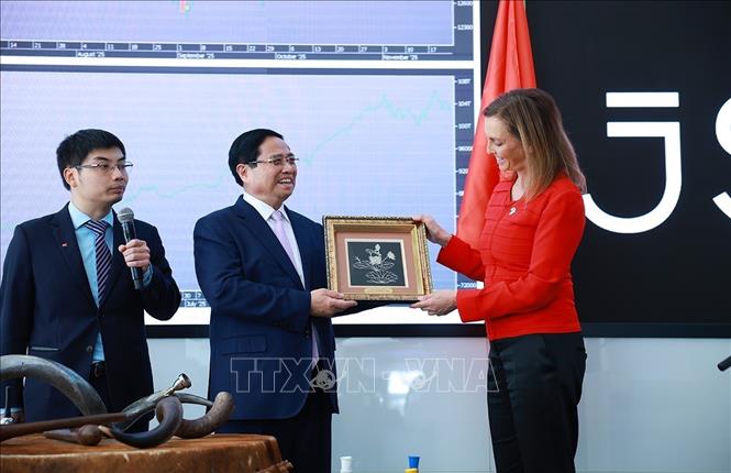 Thủ tướng Phạm Minh Chính tặng quà lưu niệm cho bà Leila Fourie, Giám đốc Thị trường Chứng khoán Johannesburg. Ảnh: Dương Giang-TTXVN