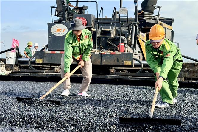 Công nhân vệ sinh, bù phụ mặt bê tông nhựa mặt đường. Ảnh: Thanh Sang-TTXVN