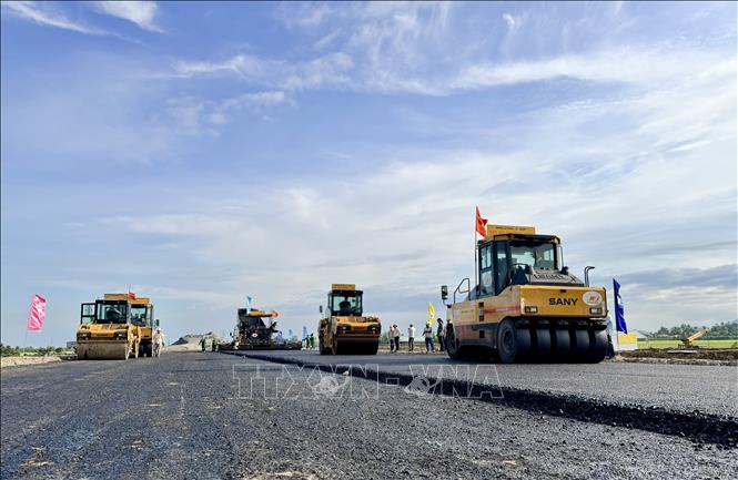 Nhà thầu Trường Sơn huy động nhiều thiết bị hiện đại thi công thảm nhựa trong chiều 21/11. Ảnh: Thanh Sang-TTXVN