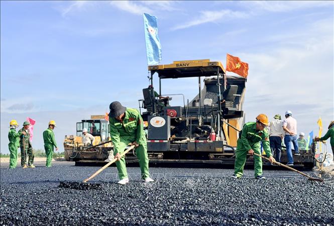 Đội thi công phối hợp nhịp nhàng giữa các khâu rải, san và lu lèn mặt đường. Ảnh: Thanh Sang-TTXVN
