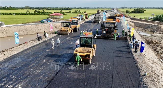 Nhà thầu Trường Sơn huy động nhiều thiết bị hiện đại thi công thảm nhựa trong chiều 21/11. Ảnh: Thanh Sang-TTXVN