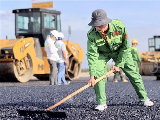 Công nhân vệ sinh, bù phụ mặt bê tông nhựa mặt đường. Ảnh: Thanh Sang-TTXVN