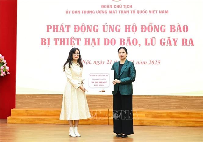 Đồng chí Hà Thị Nga, Ủy viên Trung ương Đảng, Phó Chủ tịch Ủy ban Trung ương MTTQ Việt Nam tiếp nhận bảng tượng trưng số tiền ủng hộ từ các đơn vị. Ảnh: Minh Đức – TTXVN