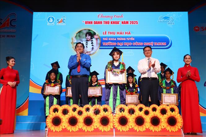 Ông Nguyễn Mạnh Cường, Phó Chủ tịch Ủy ban nhân dân Thành phố Hồ Chí Minh trao bằng khen cho các thủ khoa. Ảnh: Thanh Vũ-TTXVN
