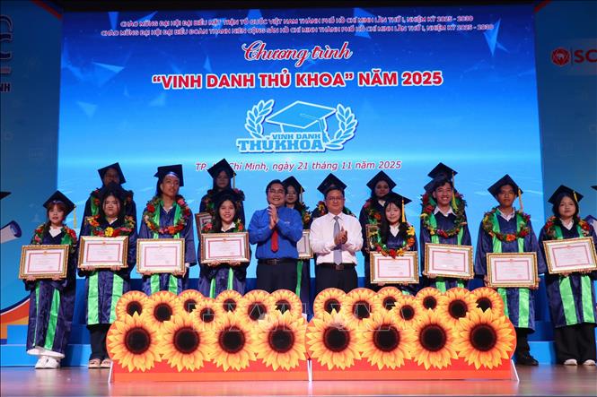 Ông Nguyễn Mạnh Cường, Phó Chủ tịch Ủy ban nhân dân Thành phố Hồ Chí Minh trao bằng khen cho các thủ khoa. Ảnh: Thanh Vũ-TTXVN

