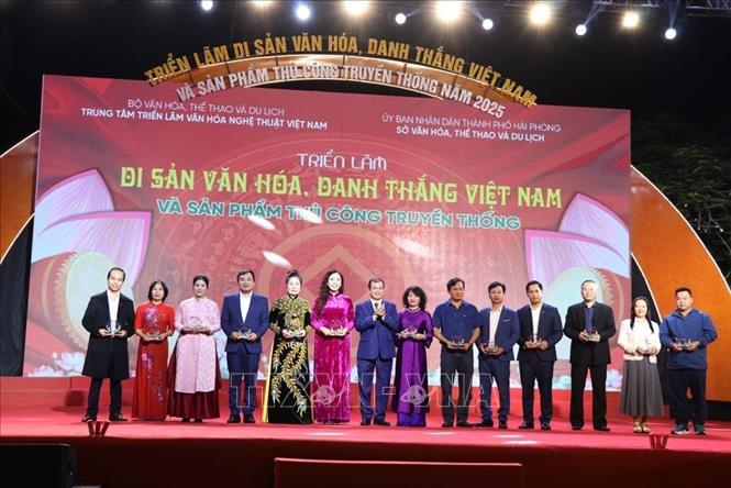 Ban tổ chức tặng biểu trưng cho các đơn vị tham gia triển lãm. Ảnh: Mạnh Minh - TTXVN