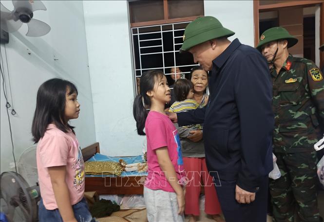 Phó Thủ tướng Thường trực Nguyễn Hòa Bình động viên các cháu học sinh được ứng cứu từ vùng ngập sâu. Ảnh: Tuấn Anh - TTXVN