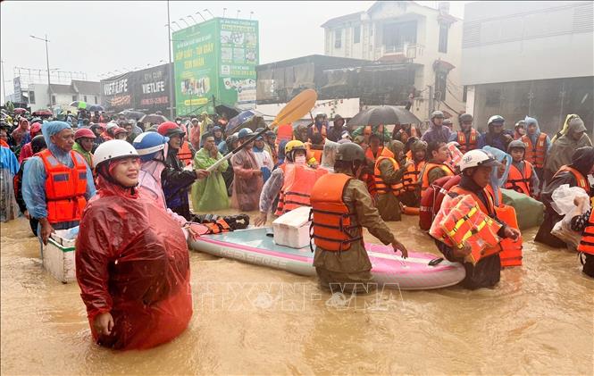  Người dân ở phường Tây Nha Trang được lực lượng chức năng sơ tán khỏi vùng ngập lụt. Ảnh: Phan Sáu - TTXVN