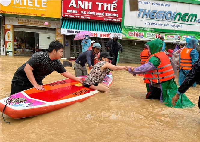  Sử dụng thuyền kayak đưa người dân vùng ngập lụt bị cô lập đến nơi an toàn. Ảnh: Phan Sáu - TTXVN