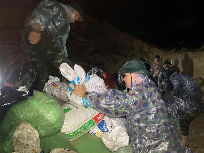  Lực lượng quân sự thành phố Đà Nẵng huy động nhân lực ngay trong đêm vận chuyển cát để khắc phục sạt lở bờ kè An Lương. Ảnh: Khoa Chương- TTXVN