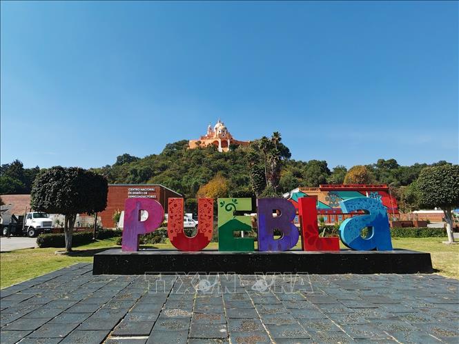 Biểu tượng chữ “Puebla” đầy màu sắc đặt tại khu du lịch Cholula, bang Puebla. Phía sau là Nhà thờ Nuestra Señora de los Remedios nổi bật trên đỉnh kim tự tháp đá lớn nhất thế giới theo thể tích nằm ẩn dưới lòng đất, thậm chí lớn hơn cả kim tự tháp Giza ở Ai Cập. Ảnh: Phương Lan- PVTTXVN tại Mexico 