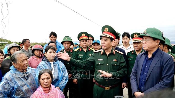 Bộ trưởng Bộ Quốc phòng Đại tướng Phan Văn Giang thăm hỏi người dân vùng lũ ở xã Tuy Phước. Ảnh: Sỹ Thắng/TTXVN