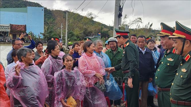 Bộ trưởng Bộ Quốc phòng Đại tướng Phan Văn Giang thăm hỏi người dân vùng lũ ở xã Tuy Phước. Ảnh: Sỹ Thắng/TTXVN