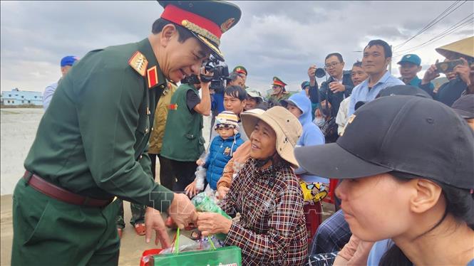 Bộ trưởng Bộ Quốc phòng Đại tướng Phan Văn Giang tặng quà người dân vùng lũ ở xã Tuy Phước. Ảnh: Sỹ Thắng/TTXVN