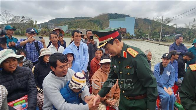 Bộ trưởng Bộ Quốc phòng Đại tướng Phan Văn Giang thăm hỏi người dân vùng lũ ở xã Tuy Phước. Ảnh: Sỹ Thắng/TTXVN
