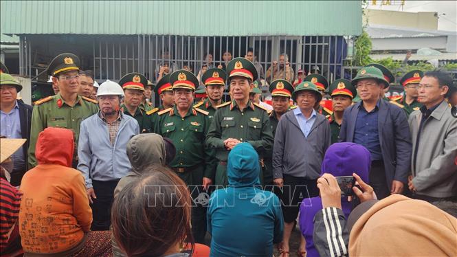 Bộ trưởng Bộ Quốc phòng Đại tướng Phan Văn Giang thăm hỏi người dân vùng lũ ở xã Tuy Phước Đông. Ảnh: Sỹ Thắng/TTXVN