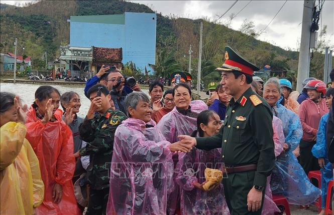 Bộ trưởng Bộ Quốc phòng Đại tướng Phan Văn Giang thăm hỏi người dân vùng lũ ở xã Tuy Phước. Ảnh: Sỹ Thắng/TTXVN