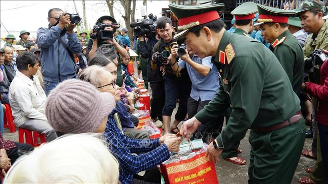 Bộ trưởng Bộ Quốc phòng Đại tướng Phan Văn Giang thăm tặng quà người dân vùng lũ ở xã Tuy Phước. Ảnh: Sỹ Thắng/TTXVN