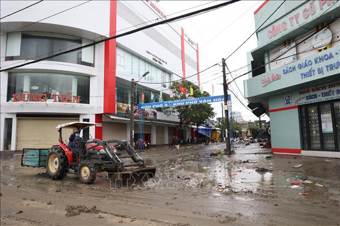 Tại trung tâm phường Tuy Hòa nước lũ rút, xe gạt được huy động để dọn bùn đất trên đường phố. Tuấn Anh – TTXVN