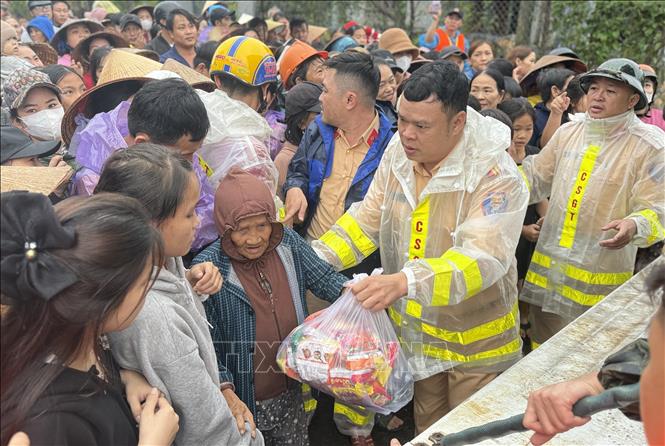 Lực lượng Cảnh sát giao thông Công an tỉnh Đắk Lắk trao những gói hàng cứu trợ đến tay người dân vùng lũ.  Ảnh: Tường Quân - TTXVN
