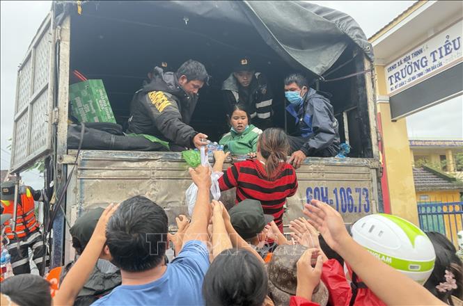 Lực lượng chức năng cung cấp lương thực, nước uống cho người dân vùng tâm lũ xã Hoà Thịnh.  Ảnh: Tường Quân - TTXVN

